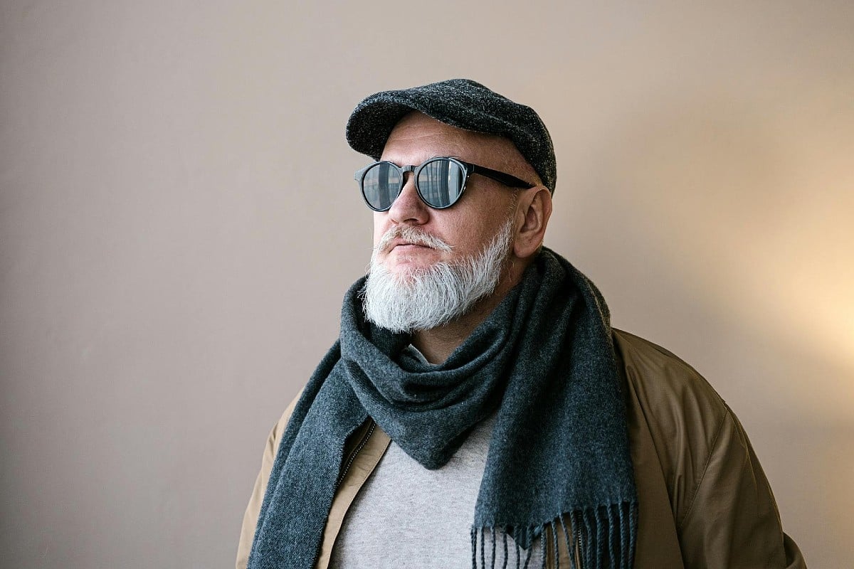 Un hombre mayor y elegante con gafas de sol, pensando en su edad y en la disfunción eréctil