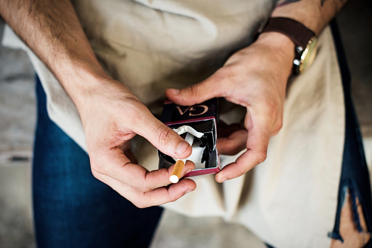 Un hombre con un cigarrillo en la entrepierna